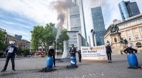 Aktivisten mit rauchendem Kraftwerk