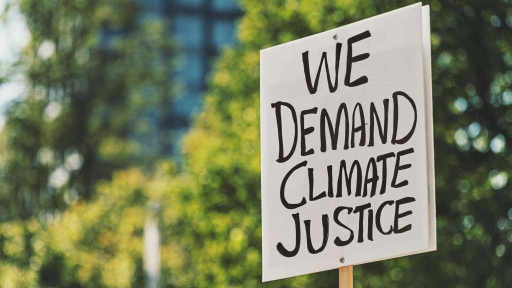 Protestschild: "We demand climate justice" (Wir fordern Klimagerechtigkeit)