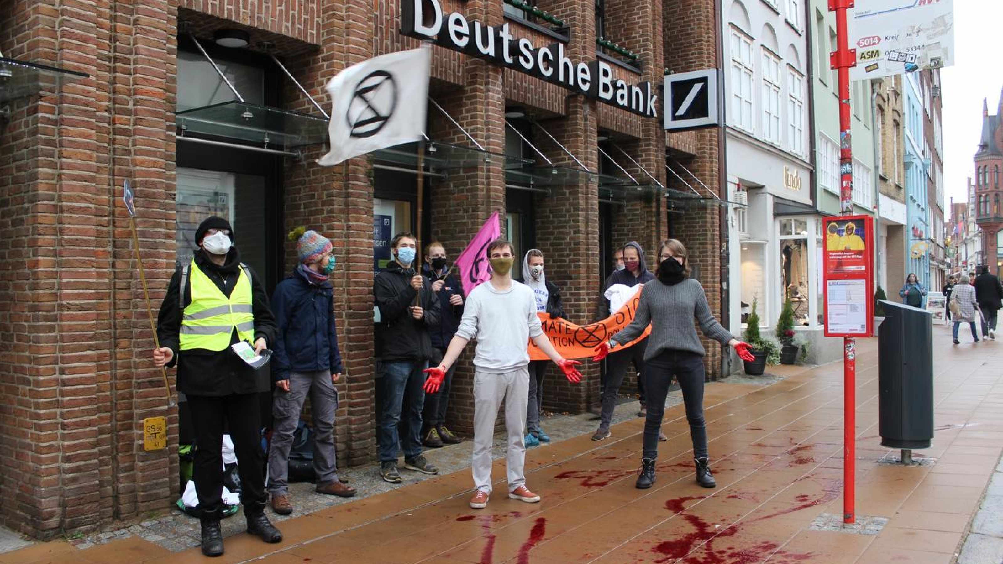 XR Lüneburg mit blutverschmierten Händen vor der Deutschen Bank