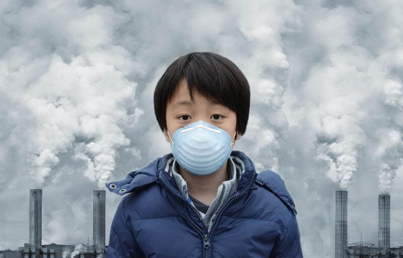 Boy in front of a coal power plant