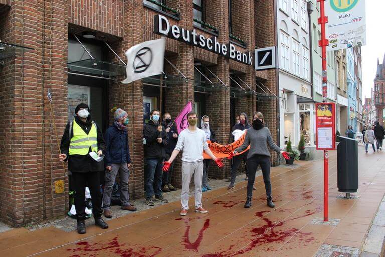 XR Lüneburg mit blutverschmierten Händen vor der Deutschen Bank