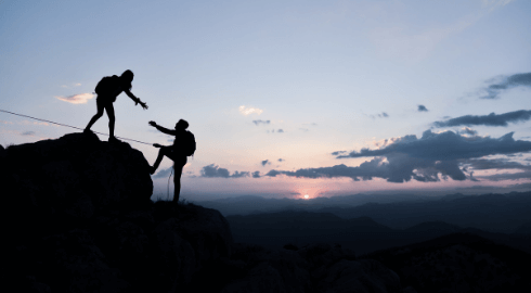 Zwei Personen erklimmen einen Berg