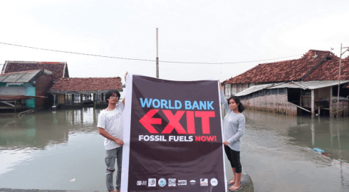 Menschen mit Protestbanner in überfluteten Straßen in Indonesien